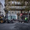 Des employés municipaux observent les vestiges calcinés d'une barricade sur le boulevard de Sébastopol, à Paris, le 19 octobre 2026. (KIRAN RIDLEY / AFP)