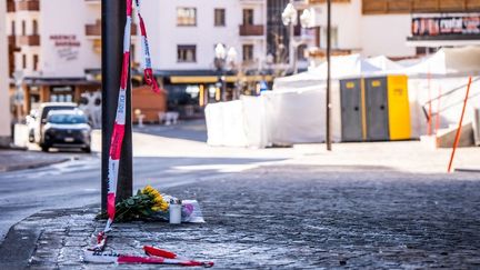 Des fleurs déposées près du bar touché par un incendie meurtrier pendant le réveillon du Nouvel An, le 1er janvier 2026 à Crans-Montana (Suisse). (MAXIME SCHMID / AFP)