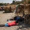 Des migrants dorment sur la plage, dans l'attente d'une place dans un centre d'accueil temporaire (CETI) à la plage de Trampolin, dans l'enclave espagnole de Ceuta (Afrique du Nord), le 15 août 2026. (JORGE GUERRERO / AFP)