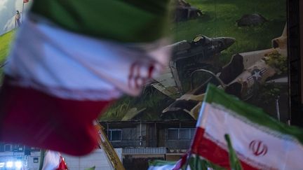 Des Iraniens brandissent des drapeaux lors d'un rassemblement progouvernemental dans le centre de Téhéran, en Iran, le 4 février 2026.