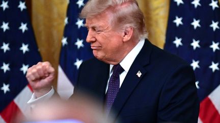 Donald Trump serre le poing lors de la cérémonie d'investiture du nouveau président de la Réserve fédérale américaine, Kevin Warsh, le 22 mai 2026, à la Maison Blanche, à Washington
