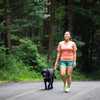 Une femme se promène avec son chien le long d'une route forestière. (Photo d'illustration) (Petesphotography / Getty Images)