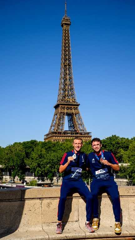 Marc-Antoine Olivier et Logan Fontaine posent avec leurs médailles devant la Tour Eiffel, aux championnats d'Europe, le 8 août 2026. (HAHN LIONEL / AFP)